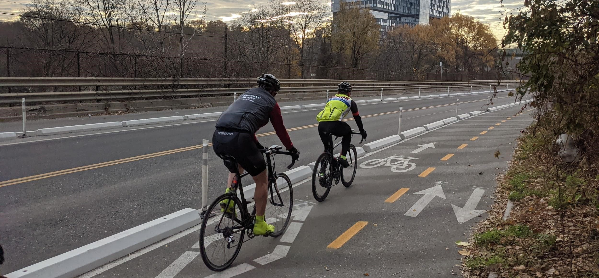 Image of Bayview Avenue after the bike lane installation with painted bike lanes separated by Image of Bloor Street after the bike lane installation with painted bike lanes separated by concrete barriers and bollards.