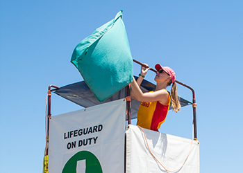 A lifeguard stand with a green flag.