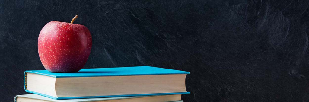 photo of books and apple stacked.